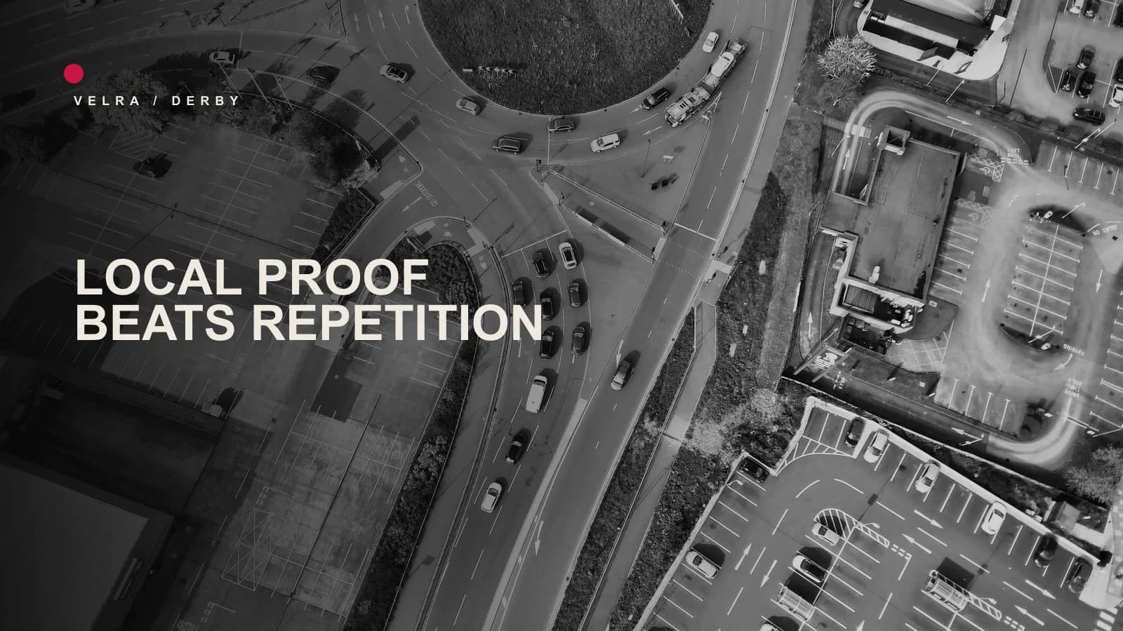 Black-and-white aerial photograph of a road junction and businesses in Derby with Velra editorial typography